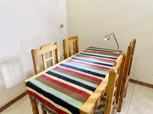 une pièce avec une table, un tapis à rayures et une lampe dans l'établissement Sunset Haven Guesthouse, à Louxor