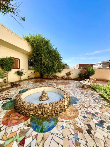 a stone courtyard with a fountain in the middle at Sunset Haven Guesthouse in Luxor