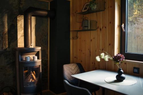 a room with a table and a wood stove at Szürke Szarvas in Szuha