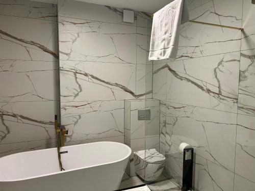 a bathroom with a white tub and marble walls at Hotel Lantier Wellness & Spa in Bytom