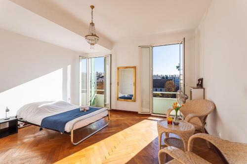 une chambre avec un lit et de grandes fenêtres dans l'établissement Ambassador Palace AP2095 by Riviera Holiday Homes, à Nice