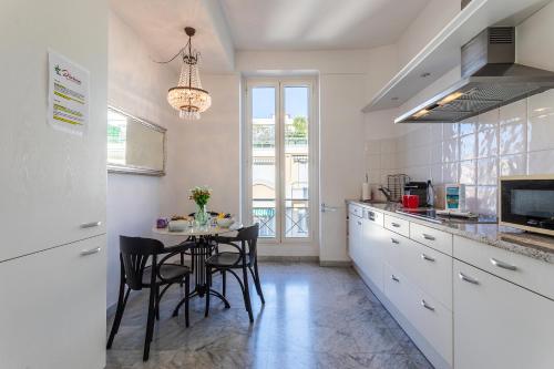 une cuisine avec une table et des chaises dans une cuisine dans l'établissement Ambassador Palace AP2095 by Riviera Holiday Homes, à Nice