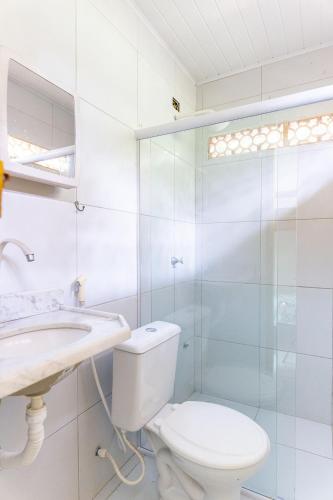 a white bathroom with a toilet and a sink at Casa c/ Piscina-4 Quartos-Barra de Catuama-SH101M in Ponta do Funil