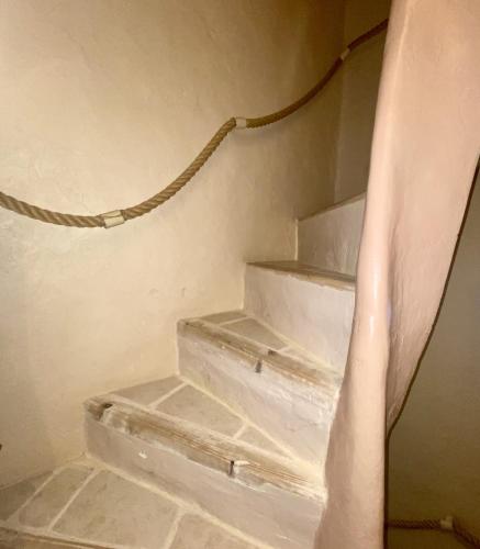 a set of stairs in a room with a curtain at Le Segarius superbe maison médiévale Internet WiFi gratuit Climatisation Jardin in Puisserguier