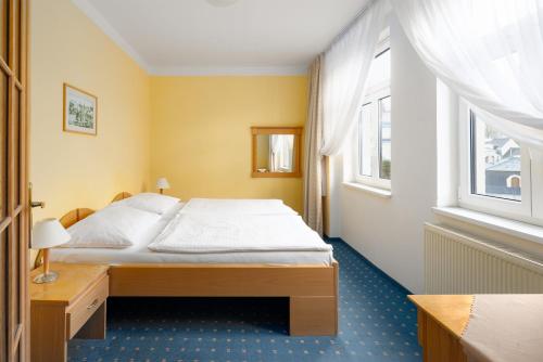 a bedroom with a bed and a window at Wellness Hotel Jean De Carro in Karlovy Vary