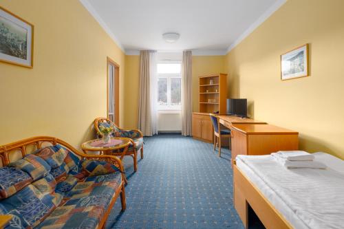 a hotel room with a bed and a desk at Wellness Hotel Jean De Carro in Karlovy Vary