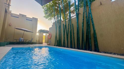 a swimming pool in front of a building with a fence at 2 Bedroom Villa in Ras Al Khaimah with Privat swimming Pool in Ras al Khaimah