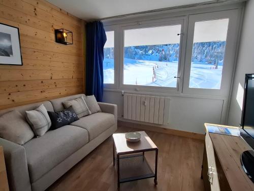 un salon avec un canapé et une chambre avec de la neige dans l'établissement Studio confortable au pied des pistes avec TV à Plagne Centre - FR-1-181-2834, à La Plagne Tarentaise