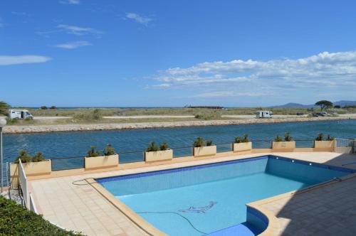 - une piscine à côté d'un corps d'eau dans l'établissement Appartement Studio cabine 4 couchages ST CYPRIEN PLAGE SC270-039, à Saint Cyprien Plage