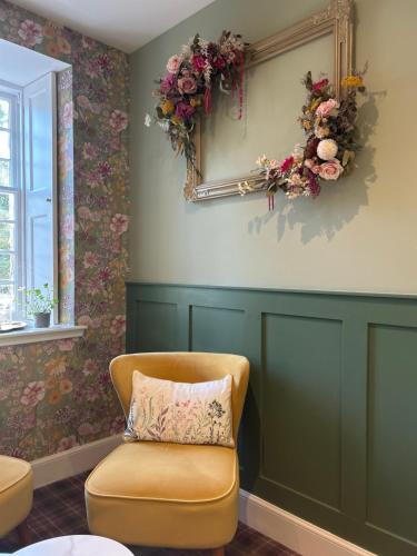 a room with a chair and a mirror and flowers at Estate Of Ord in Muir of Ord