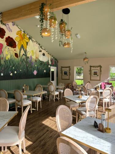 a restaurant with tables and chairs and a flower mural at Estate Of Ord in Muir of Ord