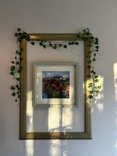 a mirror with a framed picture on a wall at Estate Of Ord in Muir of Ord