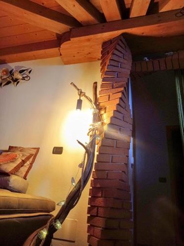 a lamp in a room with a brick wall at Chalet du soleil in Odecla