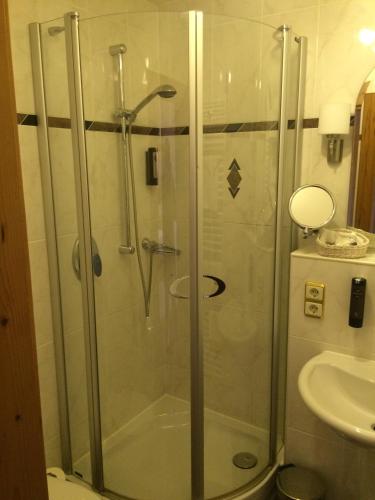 a shower with a glass door in a bathroom at Schloss Hotel Holzrichter in Nachrodt-Wiblingwerde