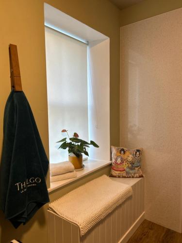 a bathroom with a window with a plant on a shelf at Estate Of Ord in Muir of Ord