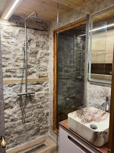 a bathroom with a sink and a shower at Old Room Bazaar in Gjirokastër