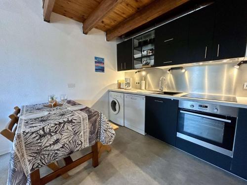 La cuisine est équipée d'une table, d'un évier et d'un lave-vaisselle. dans l'établissement Maison 2 pièces Mezzanine 5 couchages SAINT CYPRIEN SC250-023, à Saint Cyprien Plage