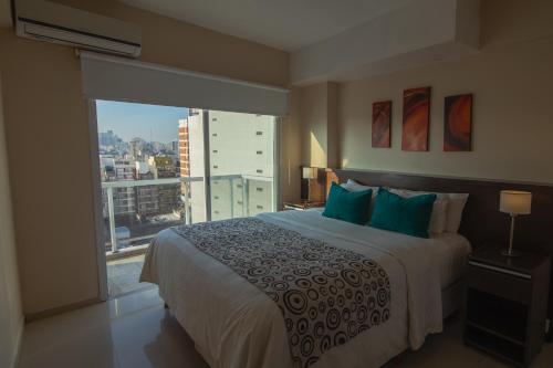 a bedroom with a large bed and a large window at Isi Baires Alquiler Temporario in Buenos Aires