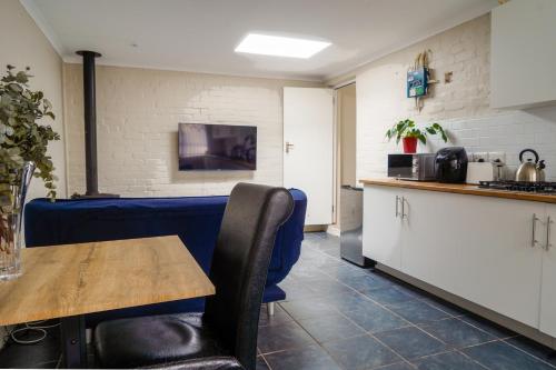 a dining room with a table and a kitchen at Cozy Cottage in Constantia in Cape Town