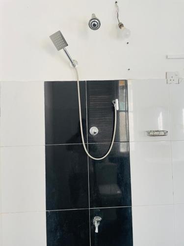 a shower with a hose in a bathroom at Villa White in Polhena