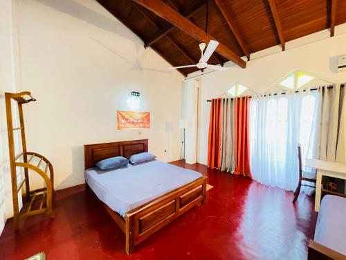 a bedroom with a bed and a chair in it at Villa White in Polhena