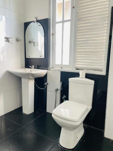 a bathroom with a white toilet and a sink at Villa White in Polhena