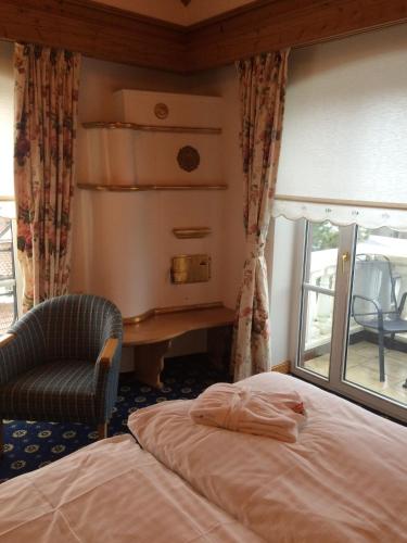 a bedroom with a bed and a chair and a desk at Schloss Hotel Holzrichter in Nachrodt-Wiblingwerde