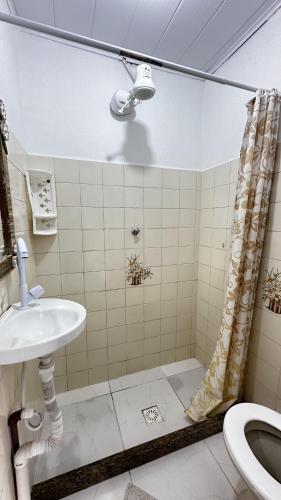 a bathroom with a sink and a shower and a toilet at Pousada Manjericão in Paraty