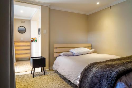 En eller flere senge i et værelse på Cozy Cottage in Constantia