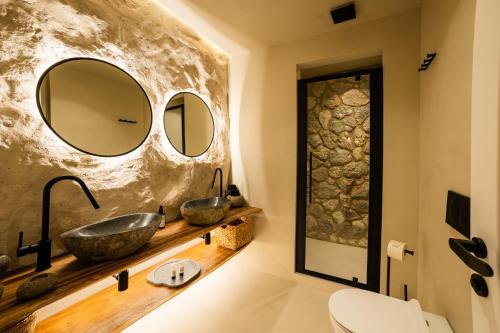 a bathroom with two sinks and two mirrors at Maison Michelangelo in Arachova