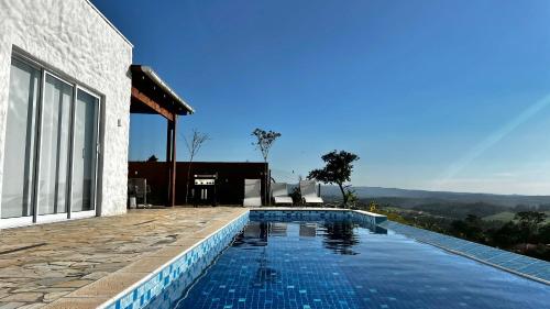 a swimming pool in front of a house at Casa Mediterrânea no alto da montanha in Itu