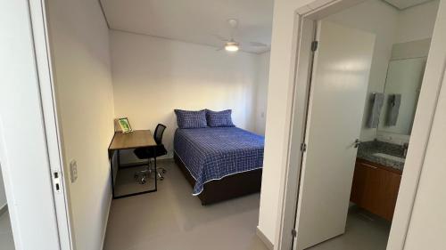 a small bedroom with a bed and a desk at Casa Mediterrânea no alto da montanha in Itu