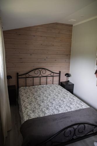 a bedroom with a bed with a wooden wall at Dom na wsi, Agroturystyka BlueBeaver in Wleń