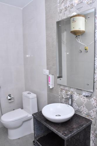 a bathroom with a white toilet and a sink at The Crown in Dharamshala