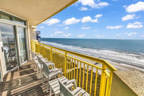 a balcony with chairs and a view of the ocean at Baywatch Resort Oceanfront Dream Maker in Myrtle Beach