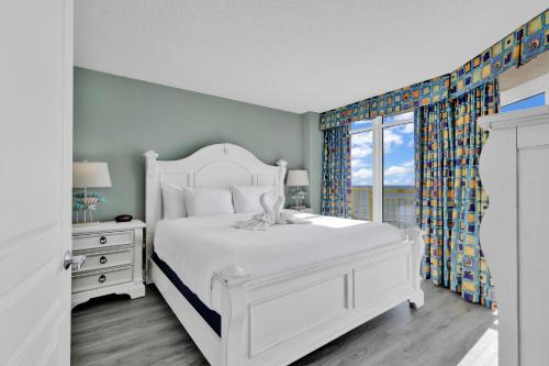 a white bedroom with a white bed and a window at Baywatch Resort Oceanfront Dream Maker in Myrtle Beach