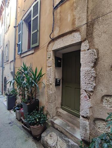 a building with a green door and some plants at Aloha in Vence