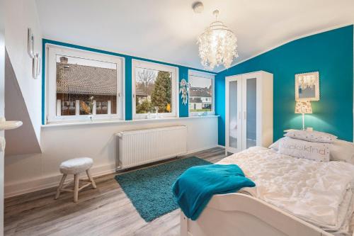 a blue and white bedroom with a bed and windows at Ferienwohnung Solling-Lounge in Holzminden