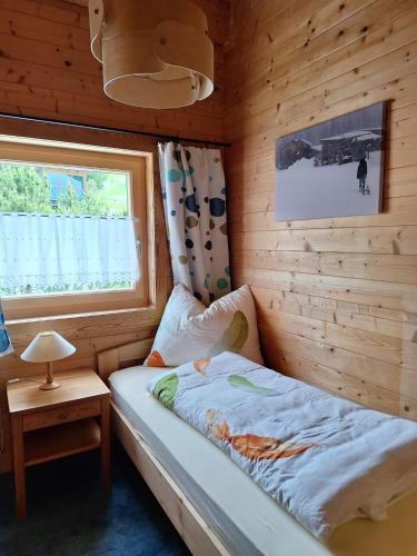 a small bedroom with a bed and a window at Chalet Siebenschläfer in Hohentauern
