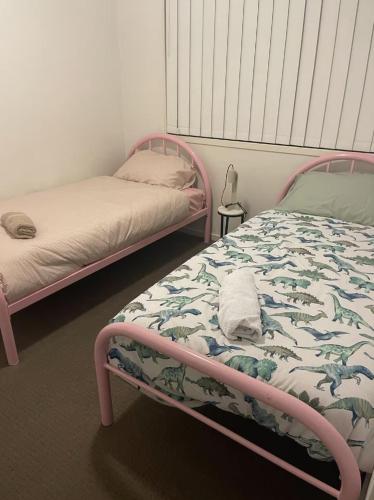 a bedroom with two beds and a bedvisor with a bedskirts at 4BR Family Home Coomera Theme Parks Shopping in Gold Coast