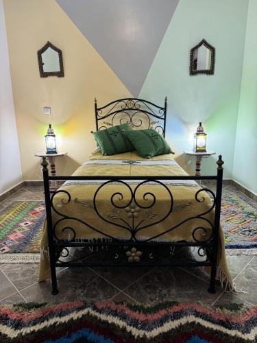 a bed in a room with two lamps and a rug at Dar Yamna Maison d'Hôtes in El Gouassem