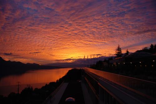 a sunset over a body of water with a bridge at Le Mirador Resort & Spa in Vevey