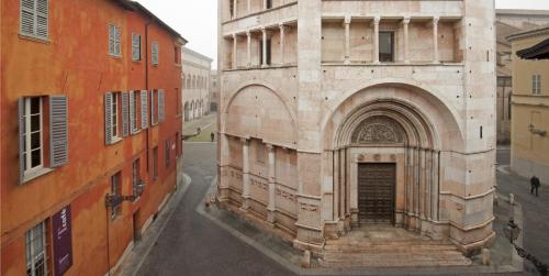 an old building with an arch in a city at Palazzo Dalla Rosa Prati in Parma