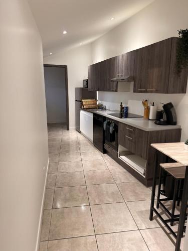 une cuisine avec des armoires en bois et un sol carrelé dans l'établissement T2 Bis, à Leyment