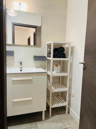 une salle de bain avec un lavabo et un miroir dans l'établissement T2 Bis, à Leyment