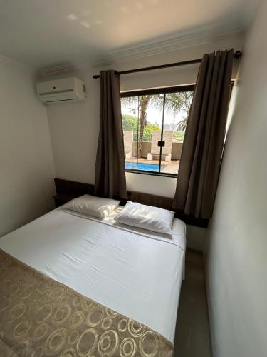 a small bedroom with a bed and a window at Hotel Holiday Foz in Foz do Iguaçu