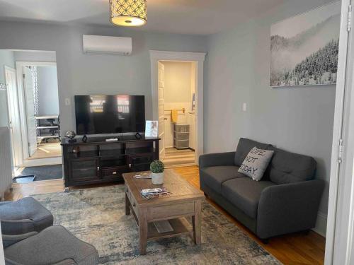 a living room with a couch and a tv at 86A King Bed 2bd 3bt on Queen St. Downtown in Charlottetown