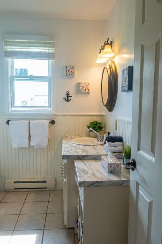 a bathroom with a sink and a window at Waterfront Cottage beach access in Stratford