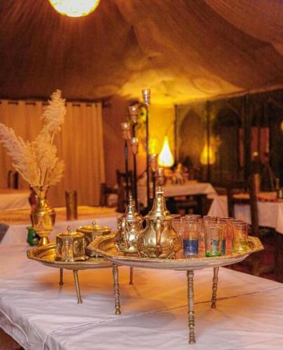 a table with a tray with glasses on it at Aladdin merzouga camp in Merzouga