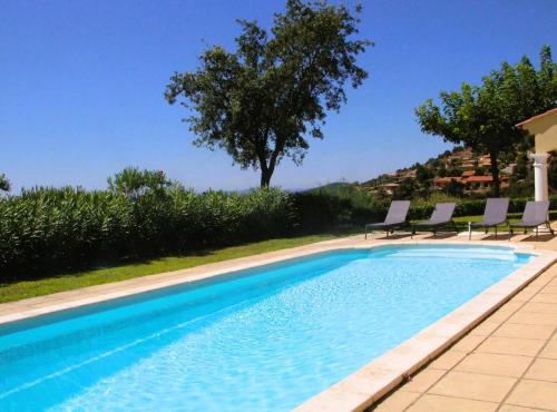 - une piscine avec des chaises à côté d'une maison dans l'établissement Villa Verde climatisée pour 10 personnes avec piscine chauffée et vue mer à La Londe les Maures, à La Londe-les-Maures